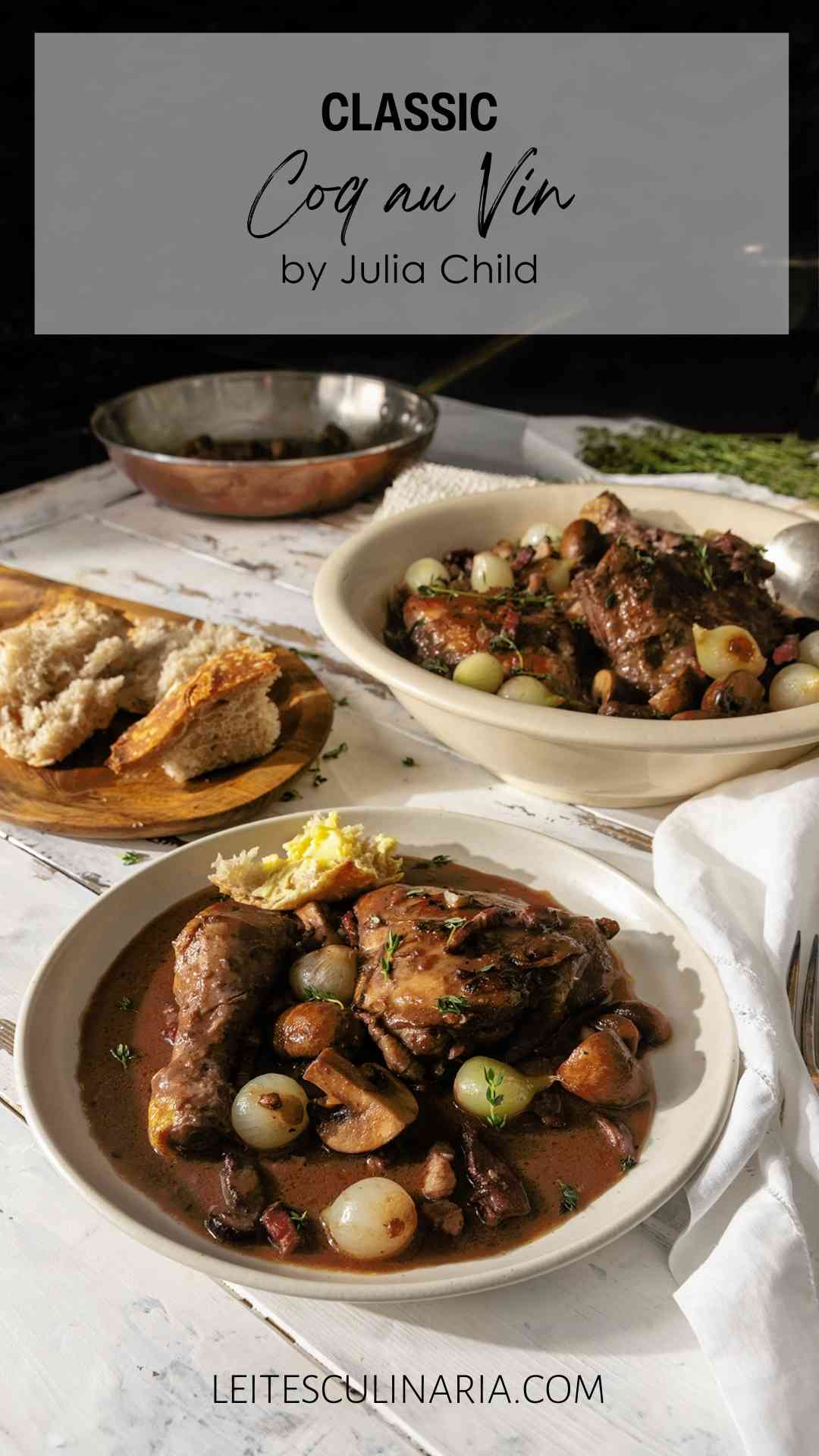 Two bowls of coq au vin on a table with sliced bread and fresh herbs.