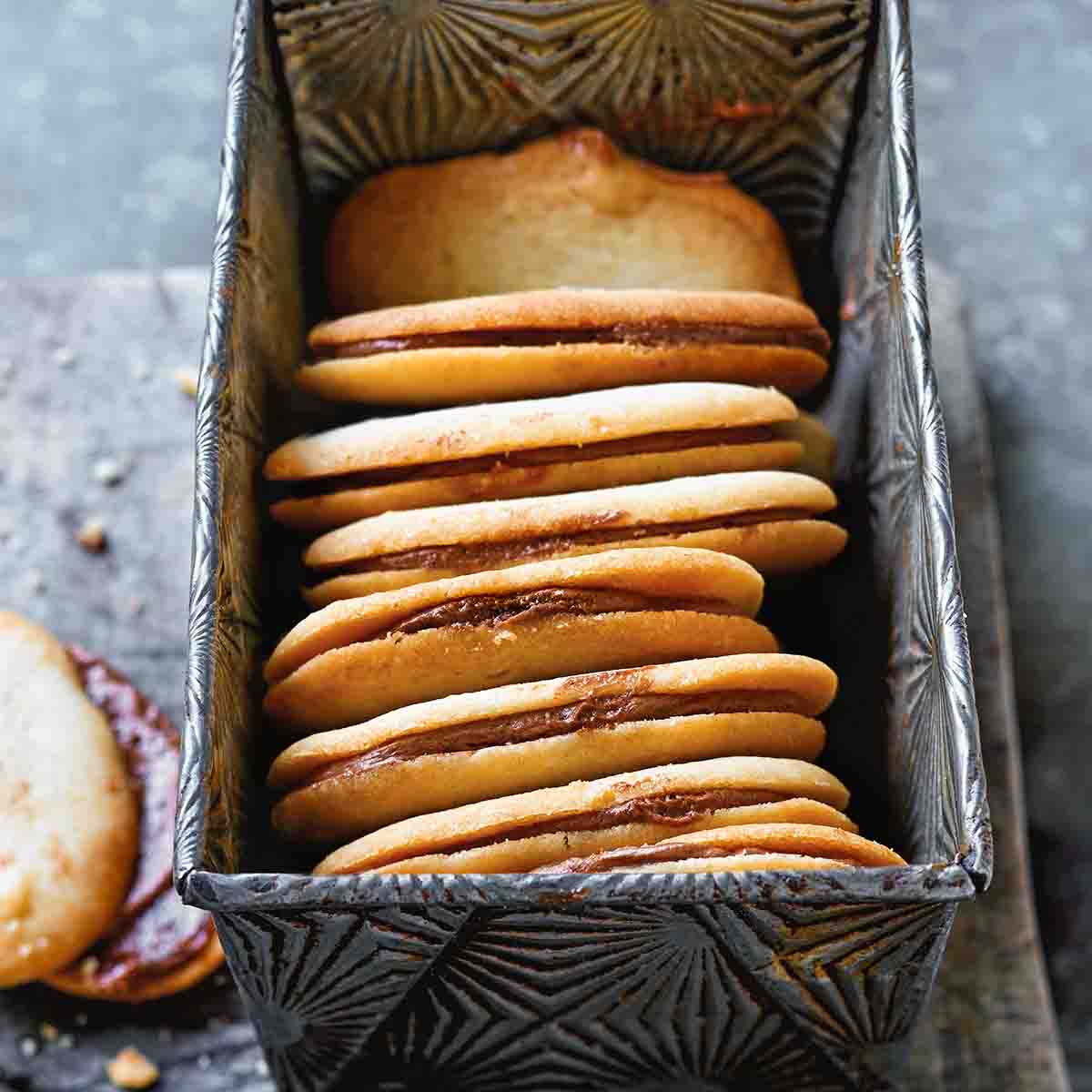 Eight homemade Milano cookies in a metal loaf tin.