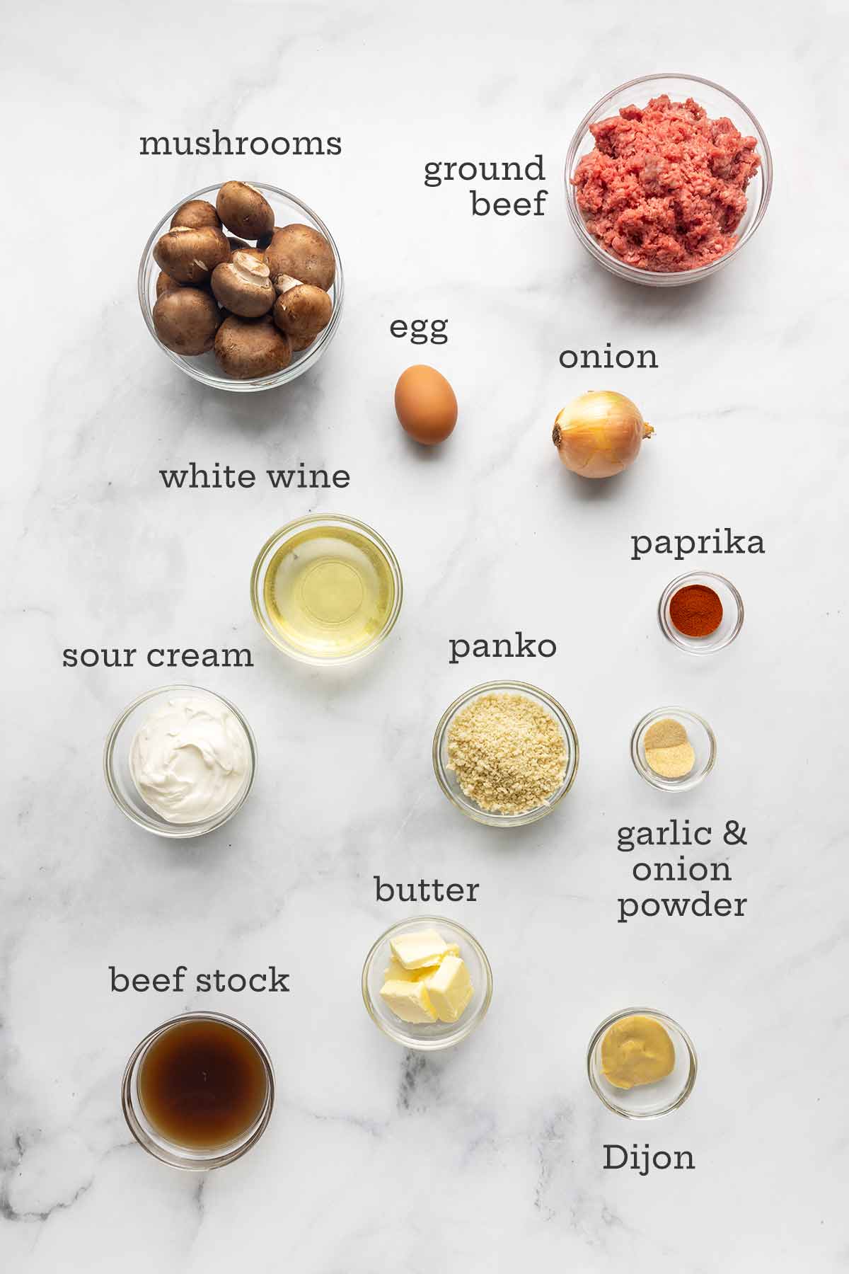 The ingredients for meatball Stroganoff--ground beef, mushrooms, white wine, sour cream, egg, onion, paprika, Dijon mustard, beef stock, butter, and garlic and onion powders.