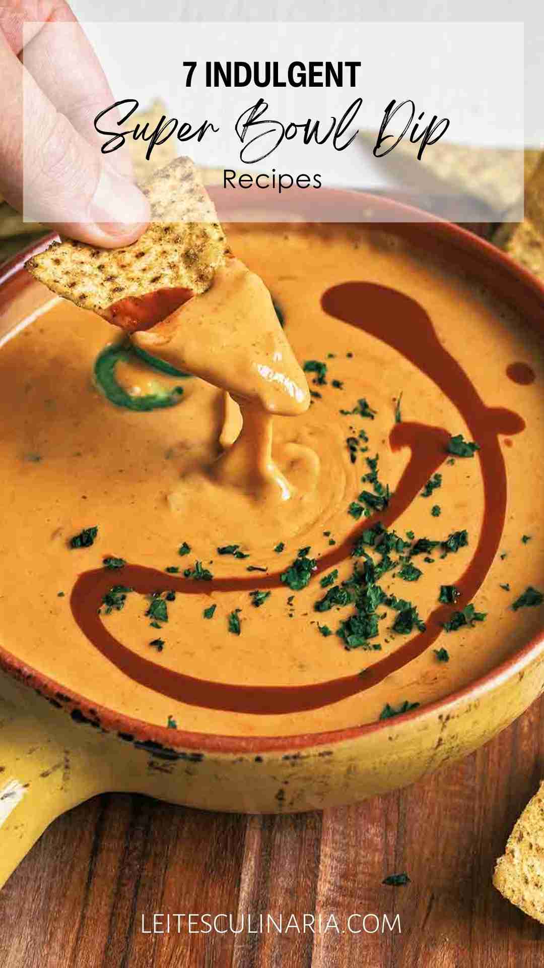 A person scooping cheese dip from a dish.