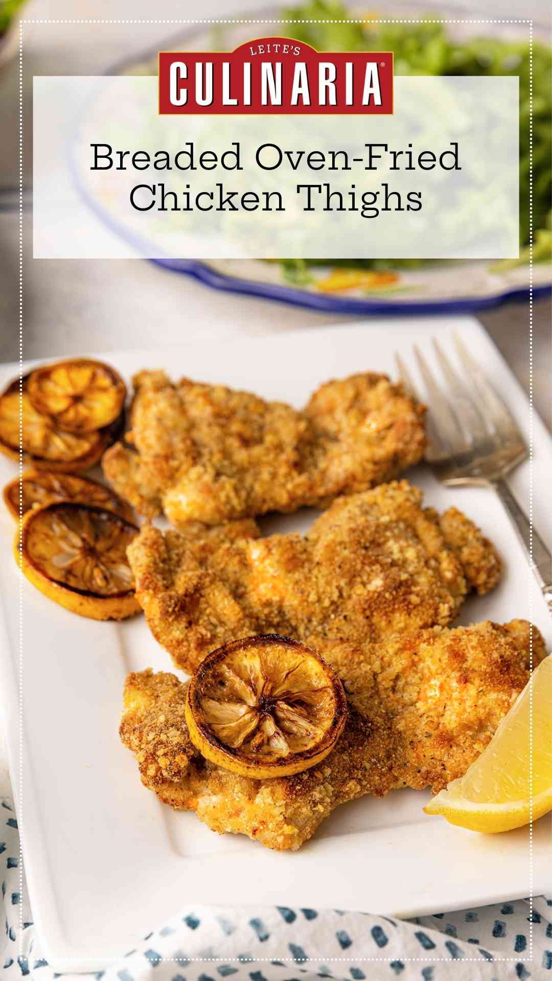Three breaded chicken thighs on a plate with slices of roasted lemon.