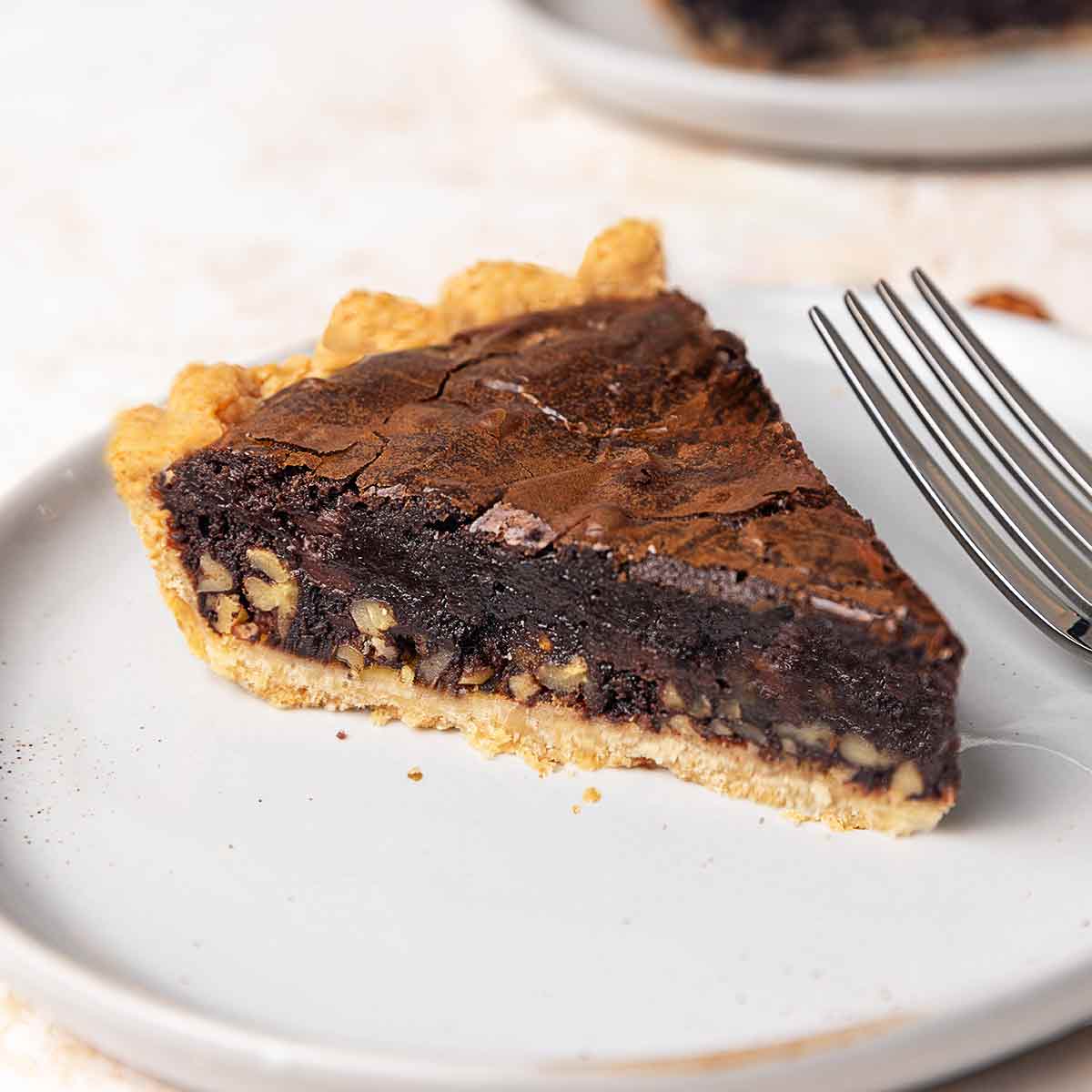 Two slices of brownie pie on plates.