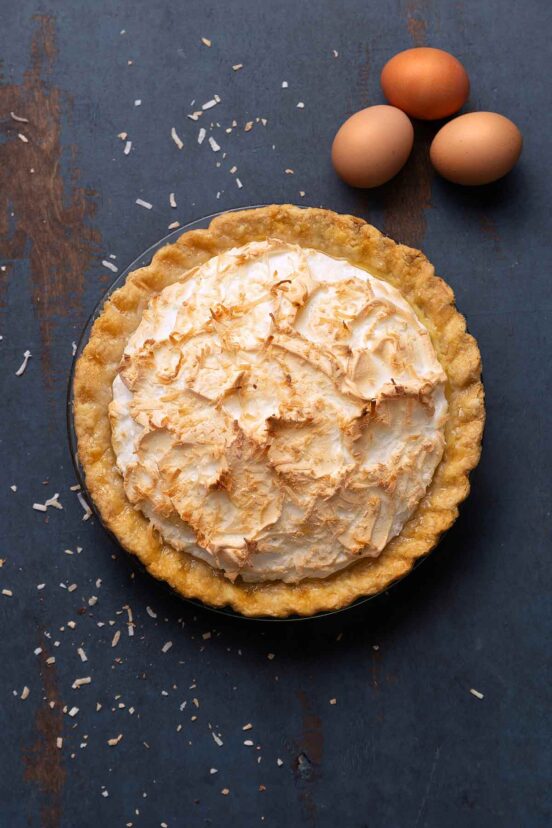A coconut cream pie with a meringue top and sprinkled with toasted shredded coconut.