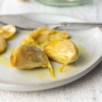Garlic confit cloves on a plate.
