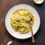 A plate filled with pasta with butter and Parmesan.