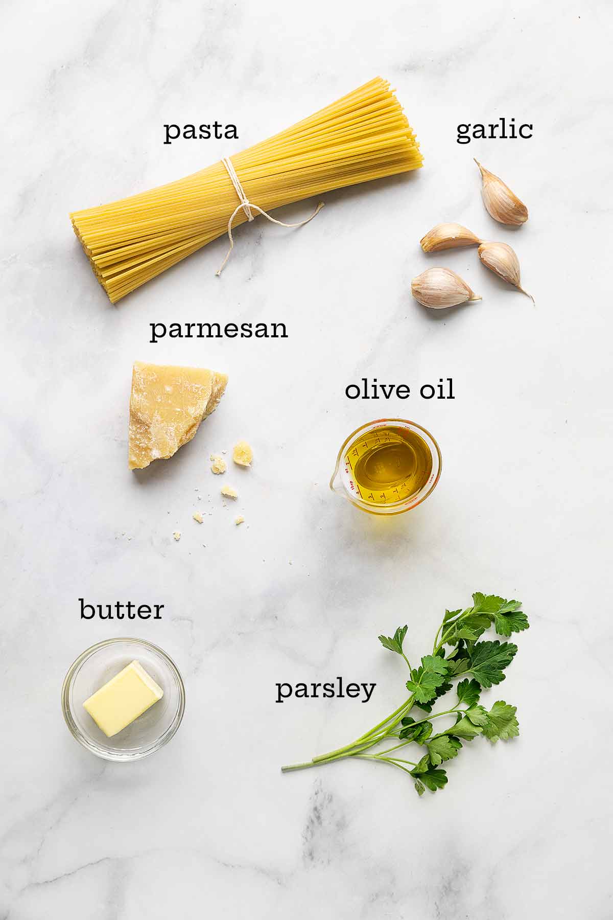 Ingredients for pasta with butter and parmesan--pasta, garlic, parmesan cheese, olive oil, parsley, and butter.