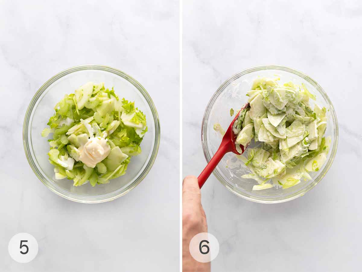 Celery leaves, celery slices, and apple slices in a bowl with a dollop of mayo on top; a person mixing everything together.