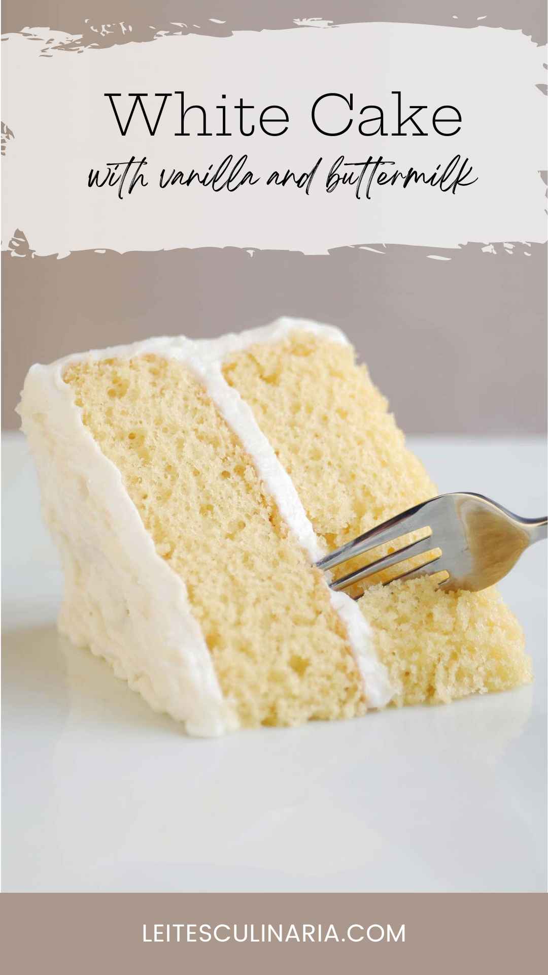 A slice of two-layer white cake with white frosting.
