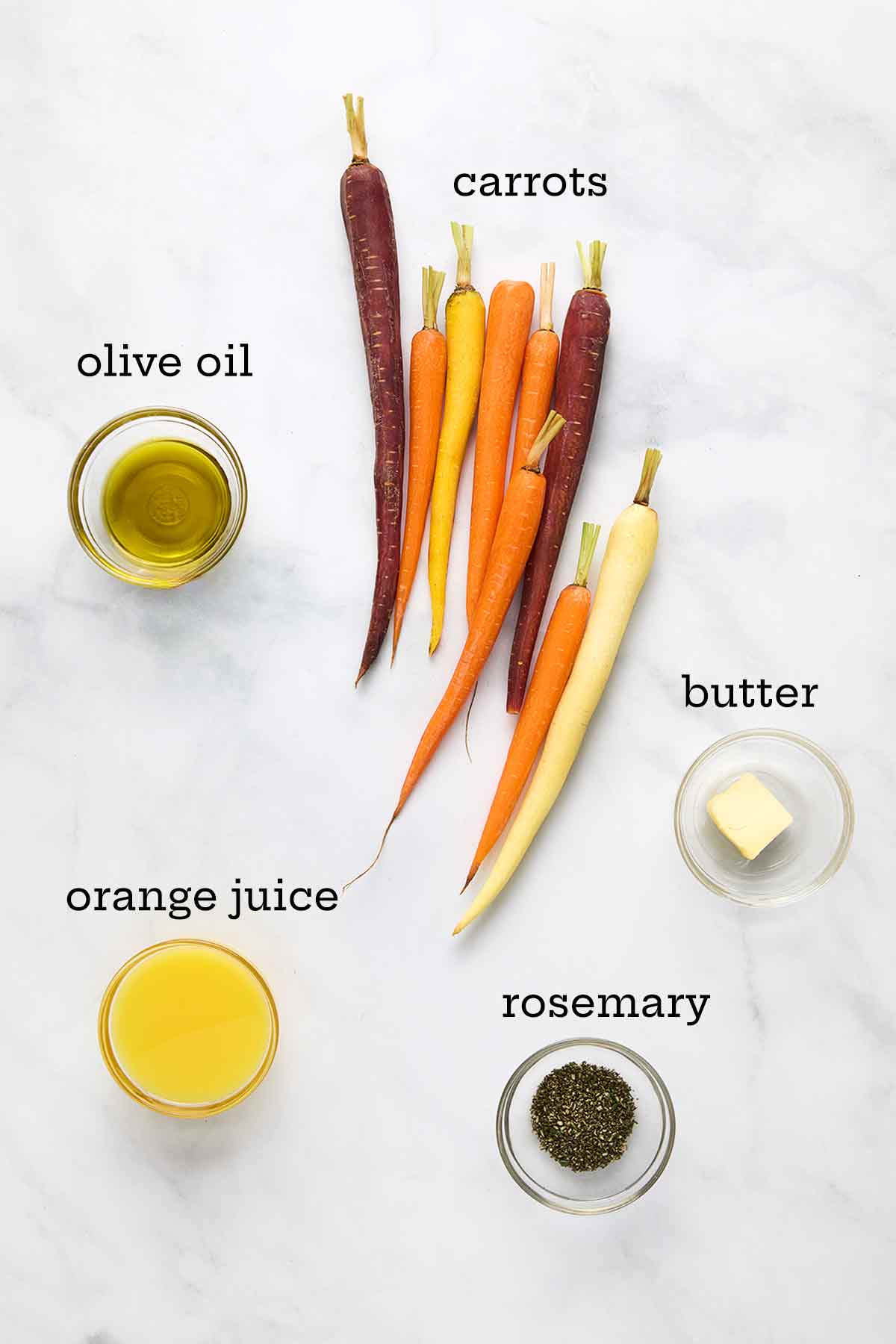 Ingredients for braised carrots--fresh carrots, olive oil, butter, orange juice, and fresh rosemary.