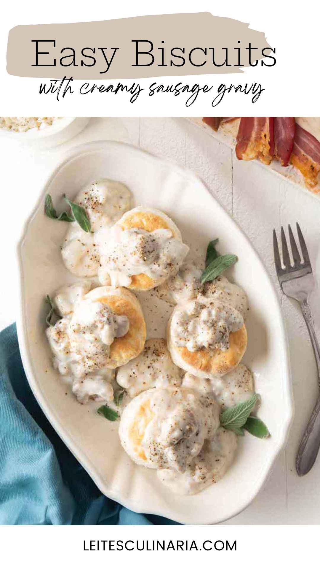 Four fluffy buttermilk biscuits in an oval baking dish, topped with white sausage gravy and fresh sage leaves.