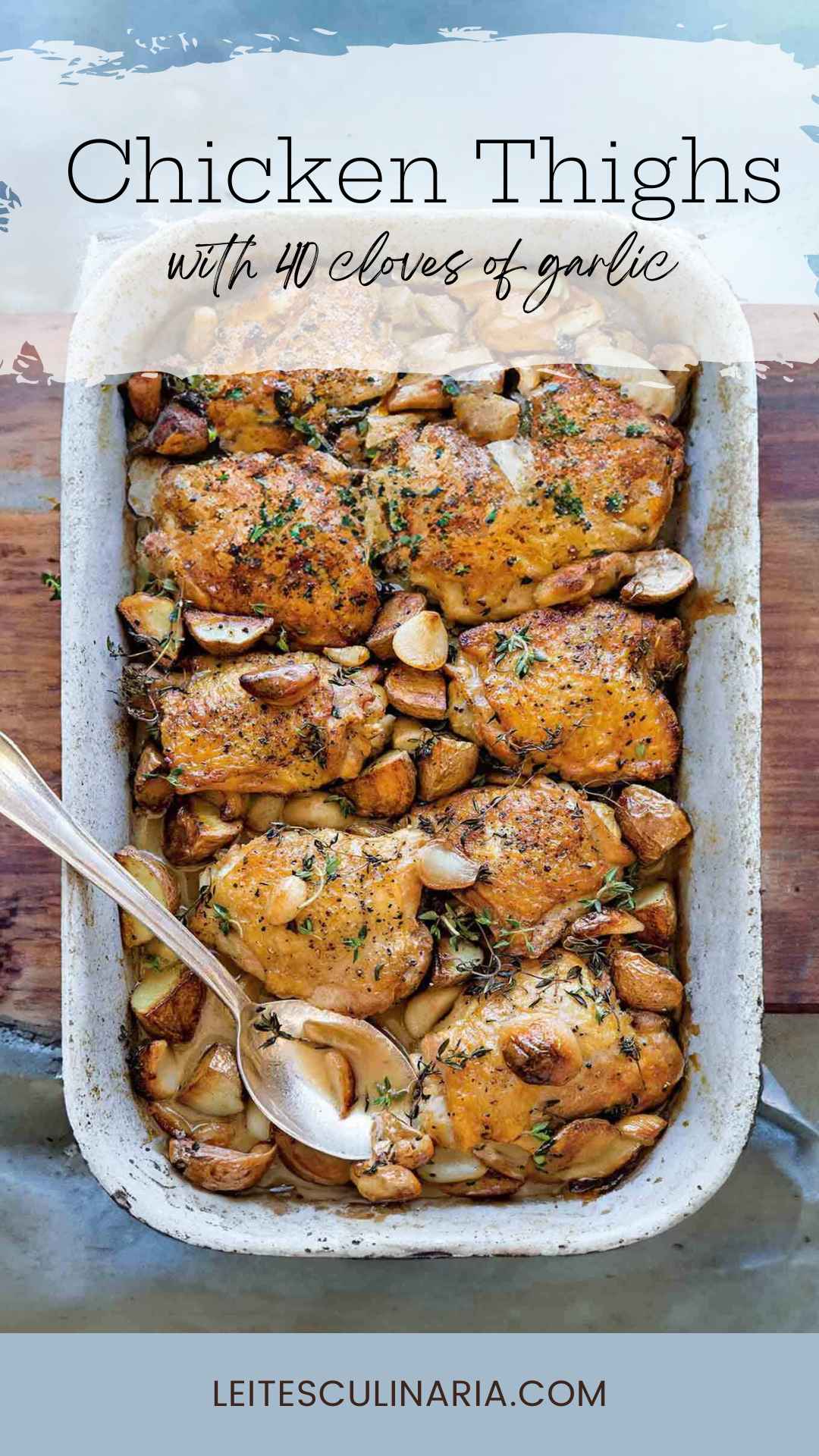 A roasting pan filled with chicken thighs, cloves of caramelized garlic, and sprigs of fresh thyme.
