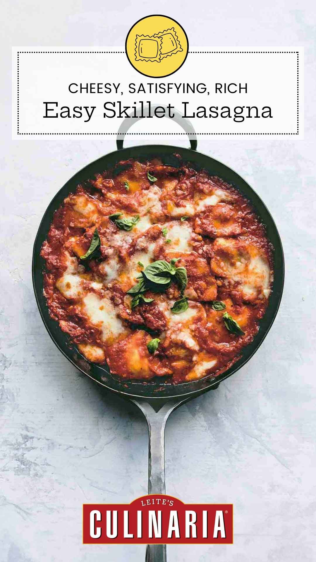 A skillet filled with ravioli in a cheesy tomato sauce with fresh basil leaves on top.
