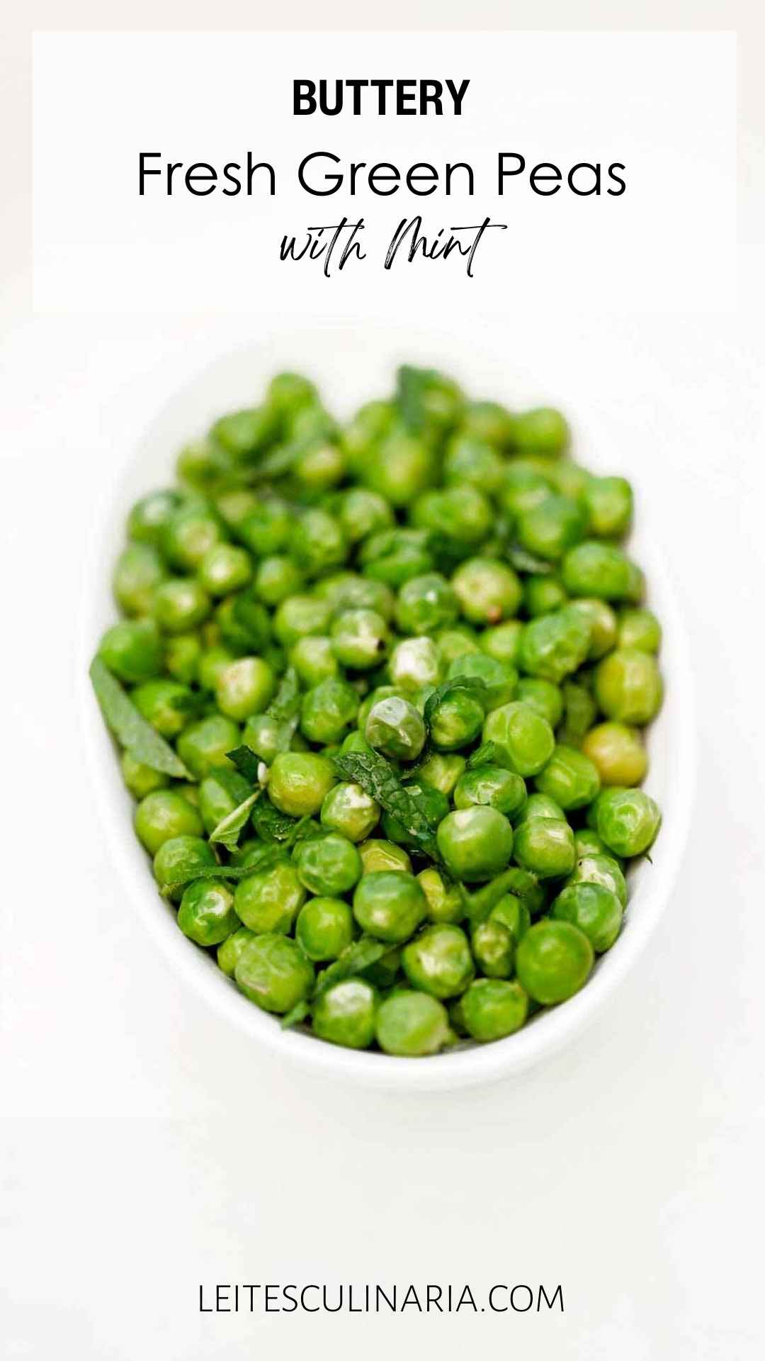 A bowl of fresh peas garnished with torn mint leaves.
