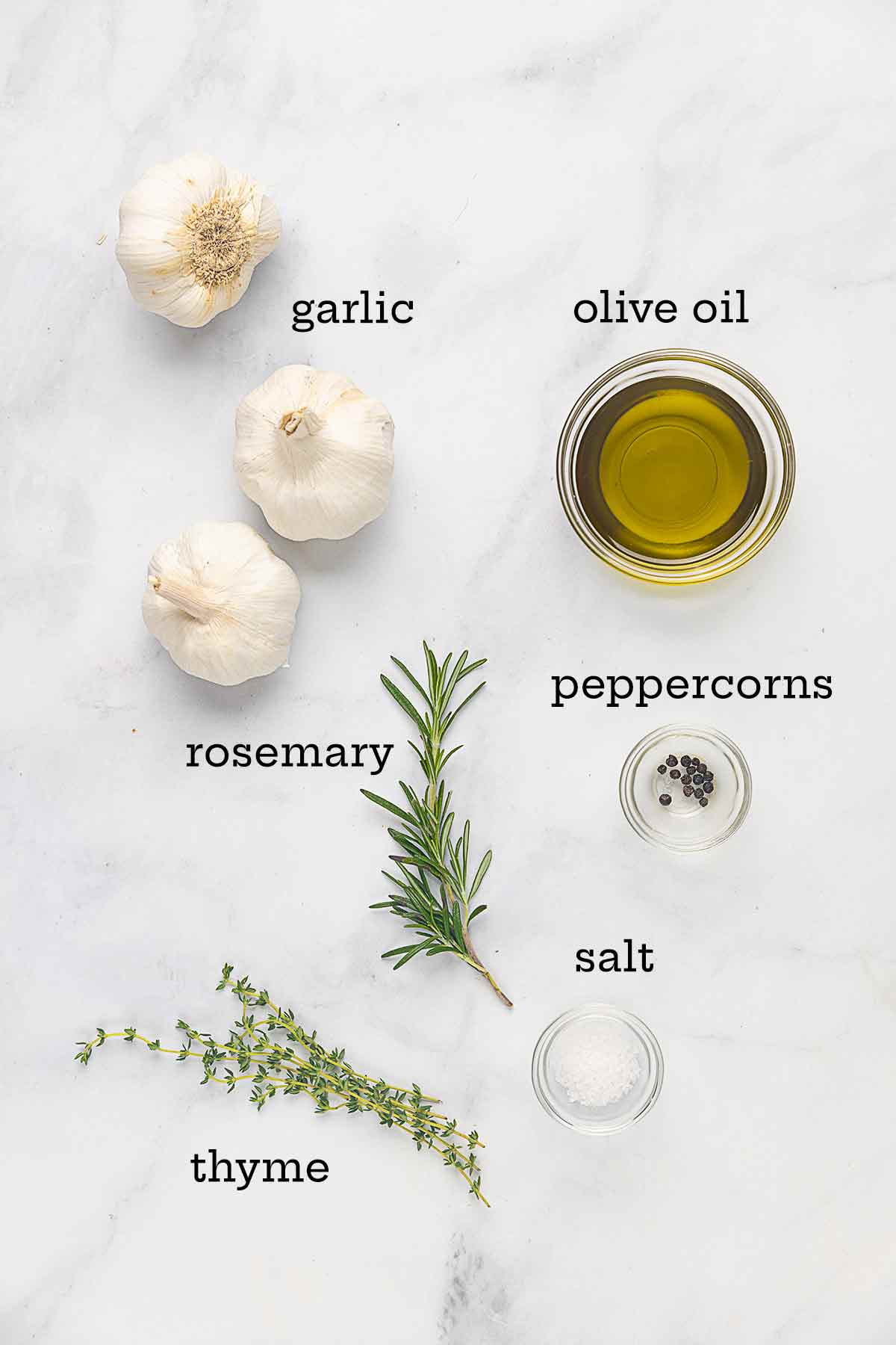 Ingredients for garlic confit--garlic, oil, rosemary, thyme, salt, and peppercorns.