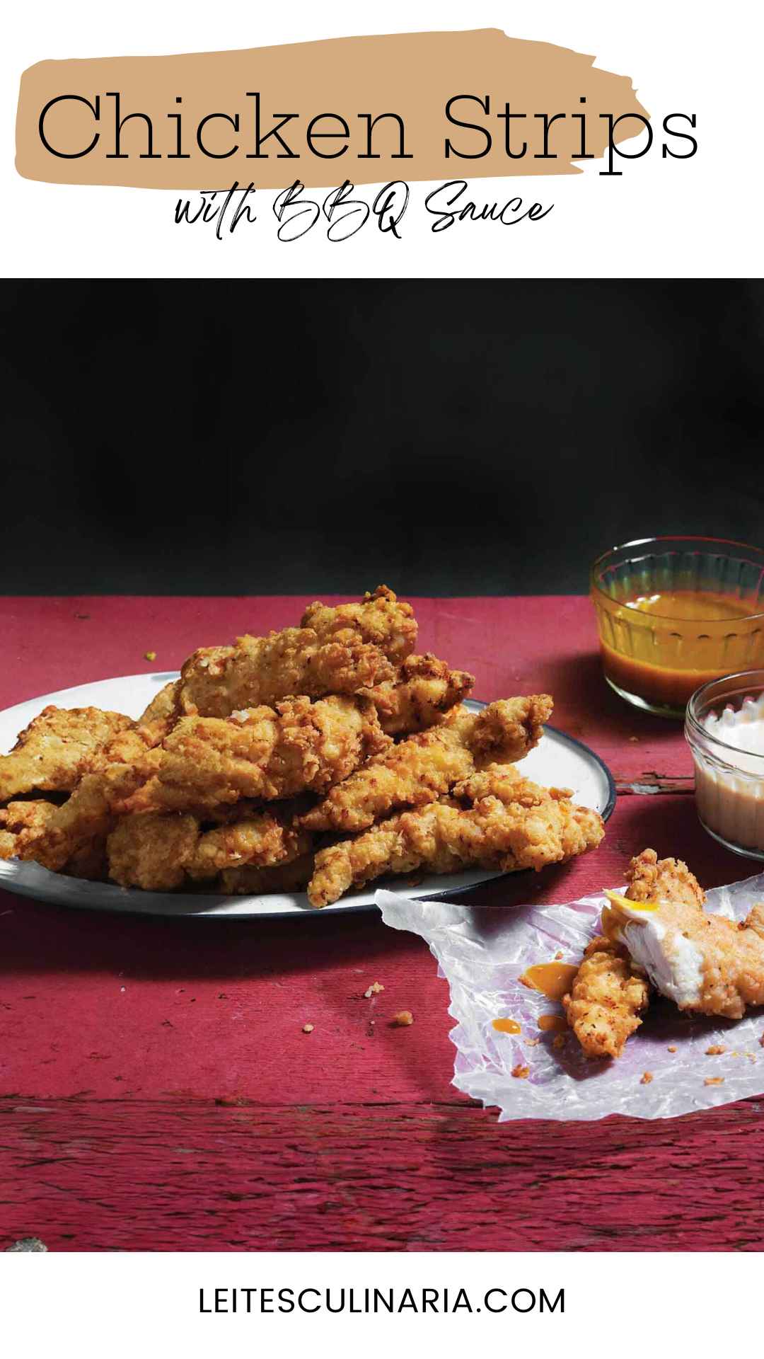 Homemade chicken strips piled on a white plate with dishes of barbecue sauce and ranch nearby.