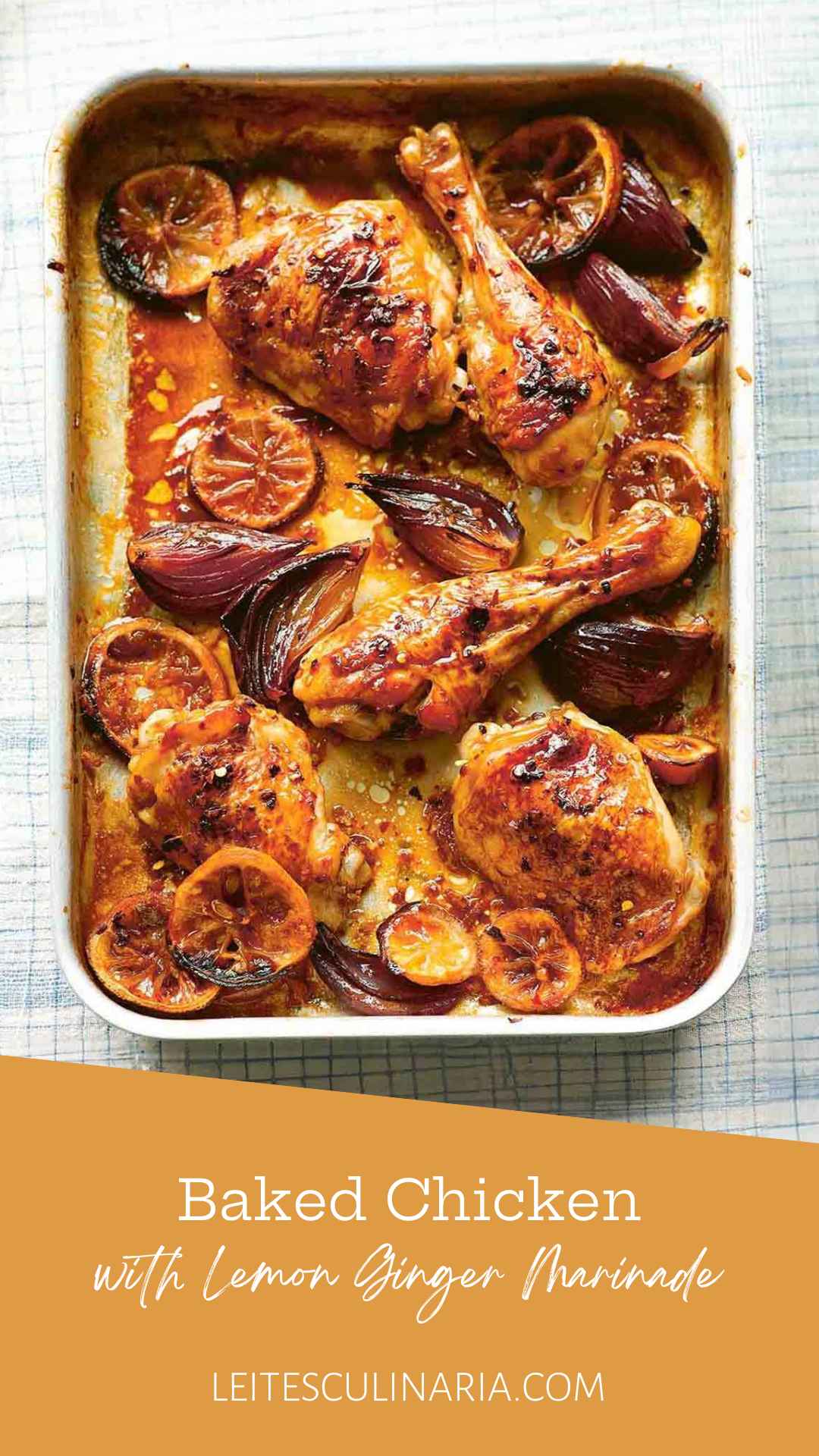 Baked chicken pieces in a baking dish with red onion wedges and lemon slices.