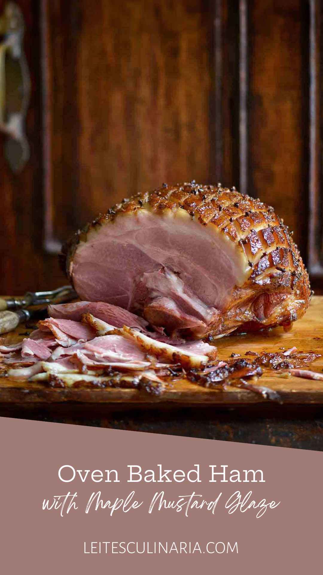A partially carved mustard-glazed ham, cross-hatched and studded with cloves on a wooden cutting board.