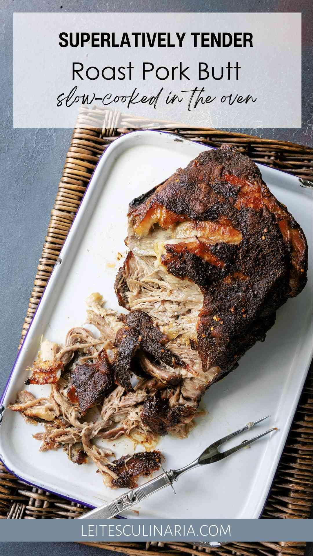 A partially shredded roast pork butt on a white tray.