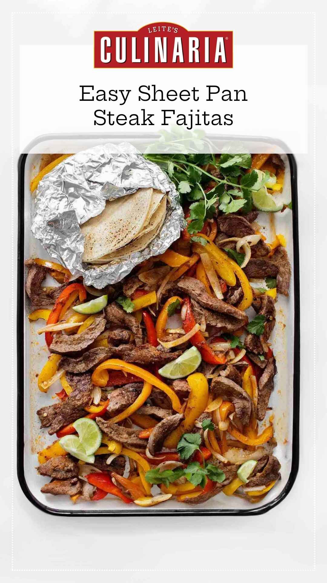 An enamel baking tray filled with sliced peppers, steak strips, onions, lime wedges, cilantro, and a foil packet of tortillas on the side.