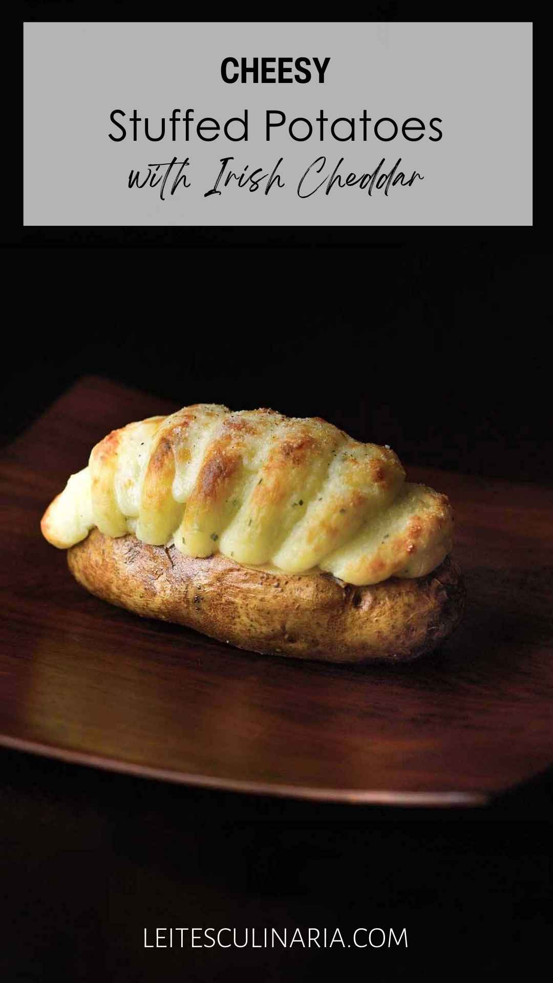 A baked potato stuffed with mashed potato and cheddar stuffing piped into it.