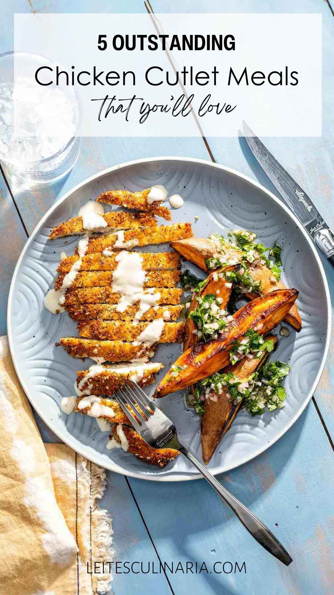 A sliced crispy chicken cutlet drizzled with white sauce and a serving of roasted potato wedges on the side.