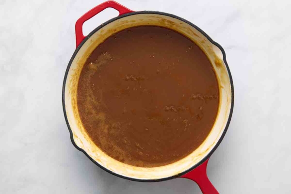 Caramel sauce cooking in a skillet.