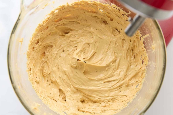 Whipped caramel frosting in a glass bowl.