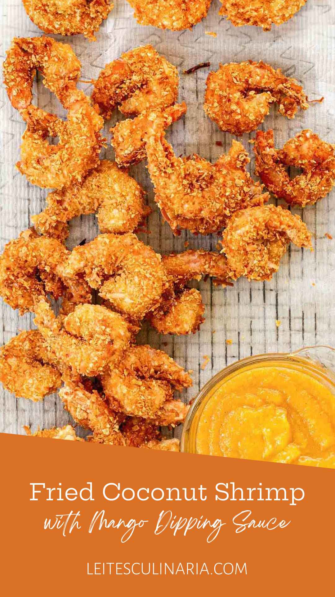 Crispy fried coconut shrimp on a wire rack with a bowl of yellow dipping sauce on the side.