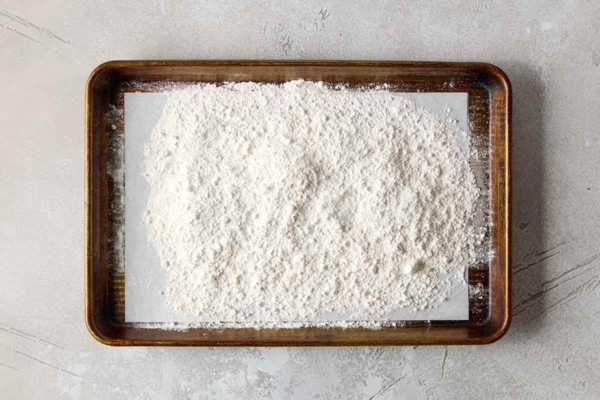 Flour spread on a parchment-lined baking sheet.