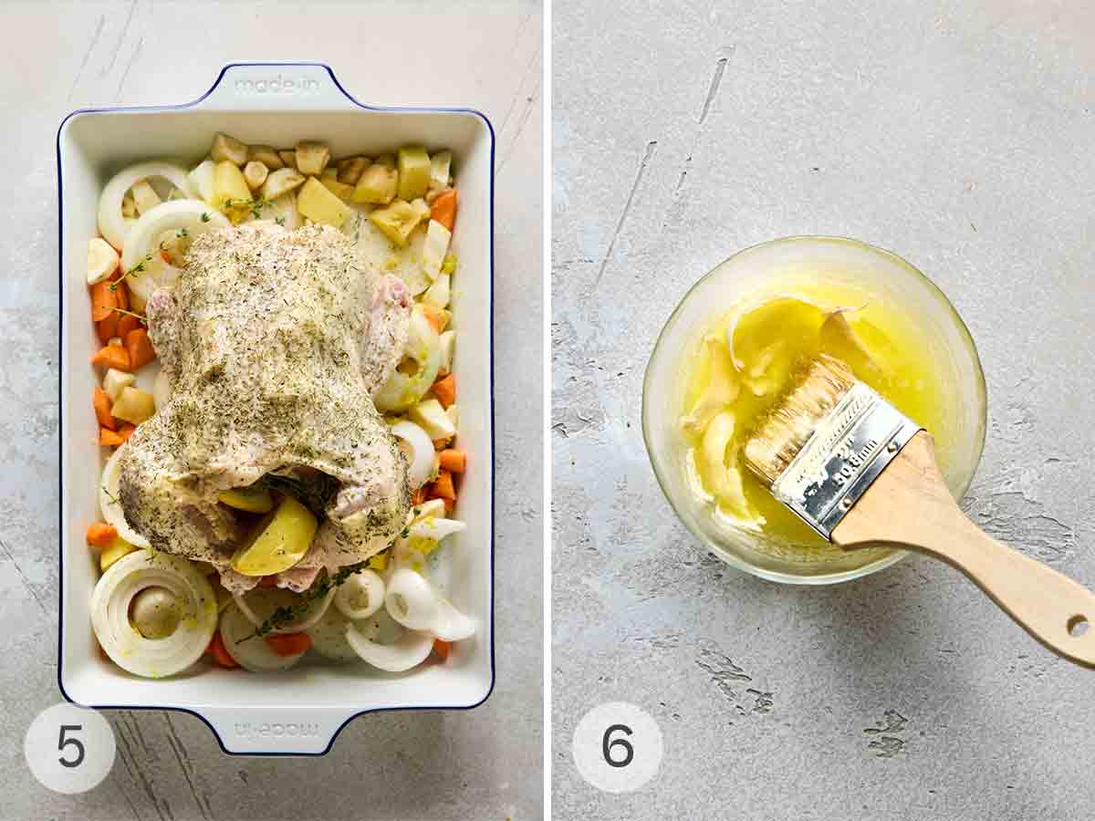 A stuffed chicken on a tray of root vegetables and onion slices; a bowl of garlic butter with a brush resting inside.