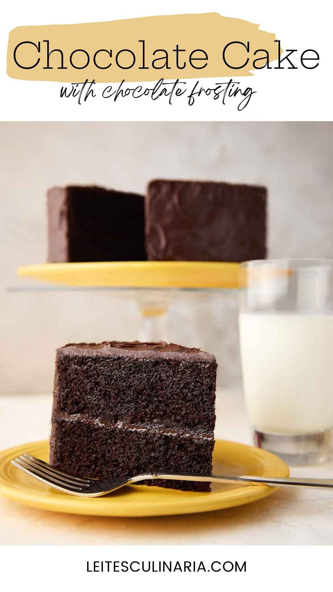 A slice of Hershey's chocolate cake with chocolate frosting on a yellow plate, with the remaining cake on a stand in the background.