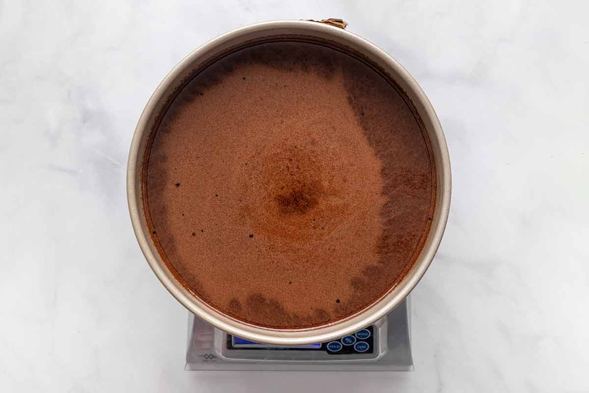A pan of chocolate cake batter on a digital kitchen scale.