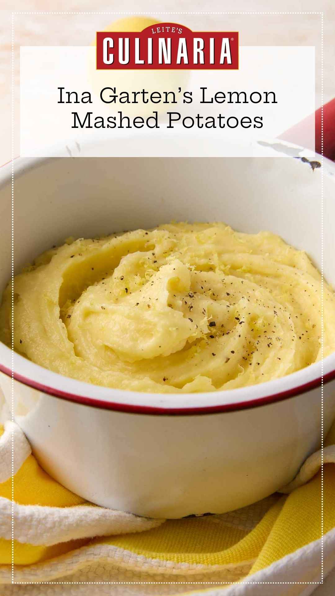 An enamel bowl filled with mashed potatoes, topped with black pepper and lemon zest.