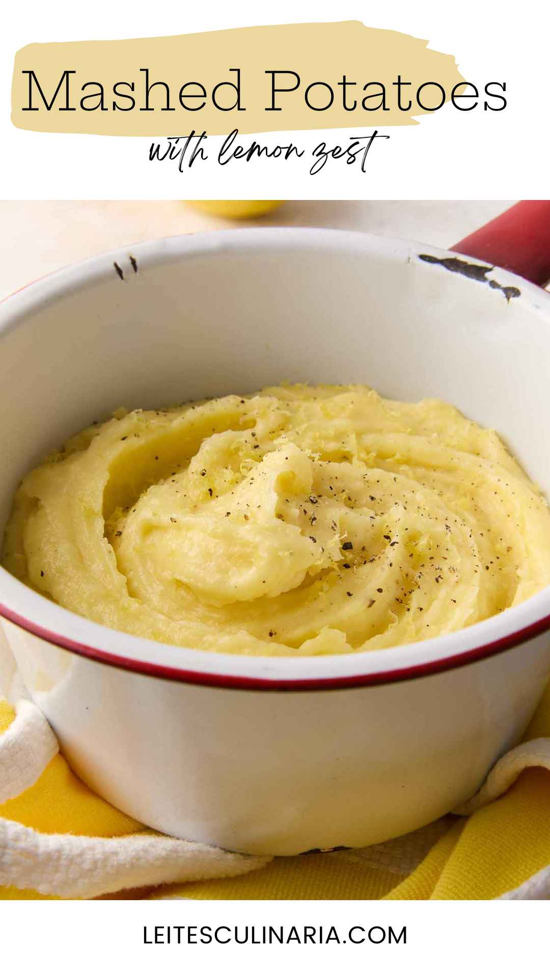 An enamel bowl filled with mashed potatoes, topped with black pepper and lemon zest.