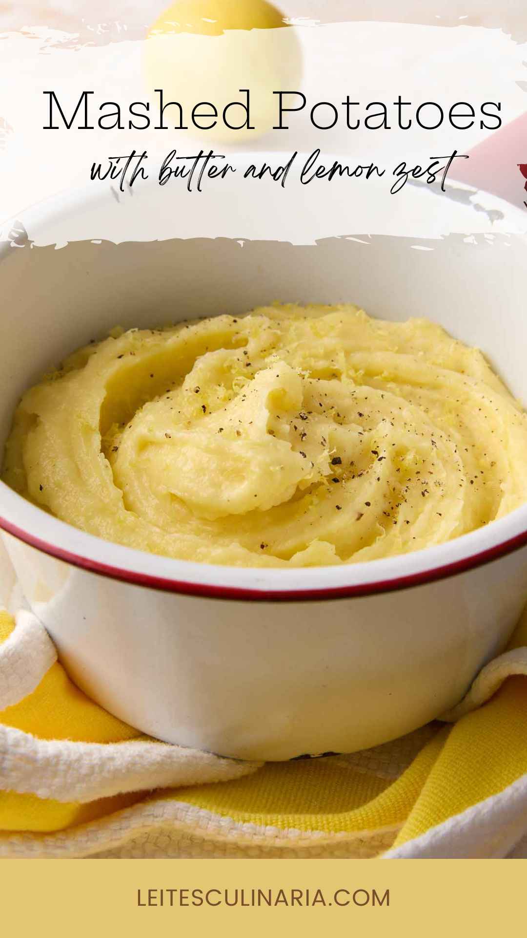 An enamel bowl filled with mashed potatoes, topped with black pepper and lemon zest.
