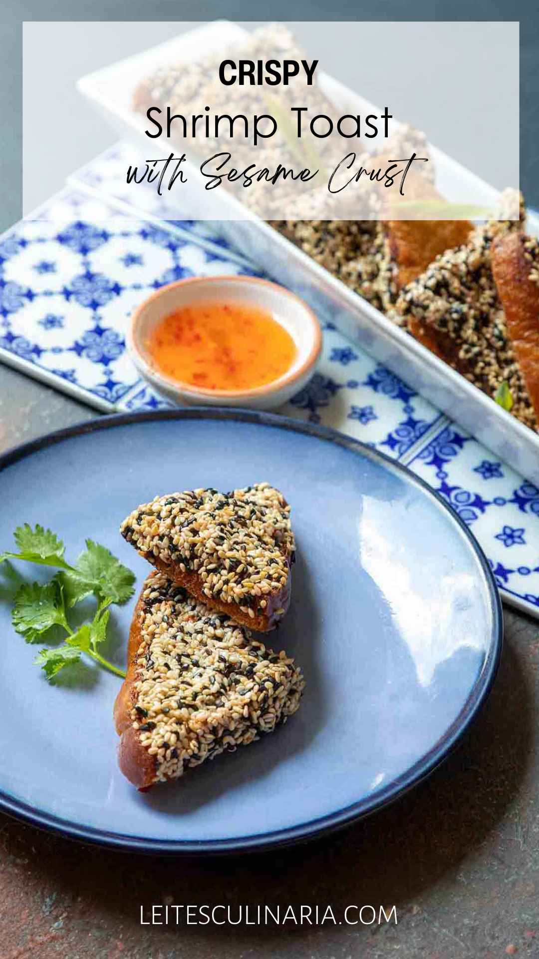 Two triangles of crispy shrimp toast on a blue plate with a sprig of cilantro and a tray of shrimp toast and dipping sauce in the background.