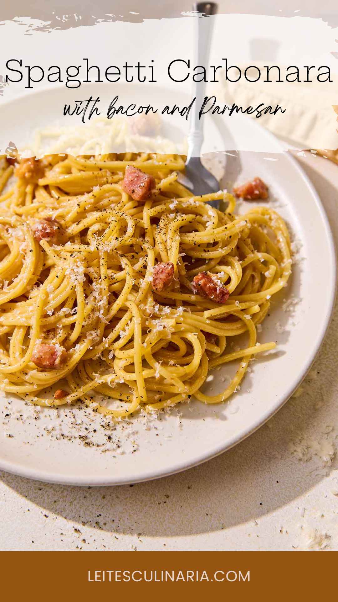A plate of spaghetti carbonara with cubes of pancetta, Parmesan, and black pepper.
