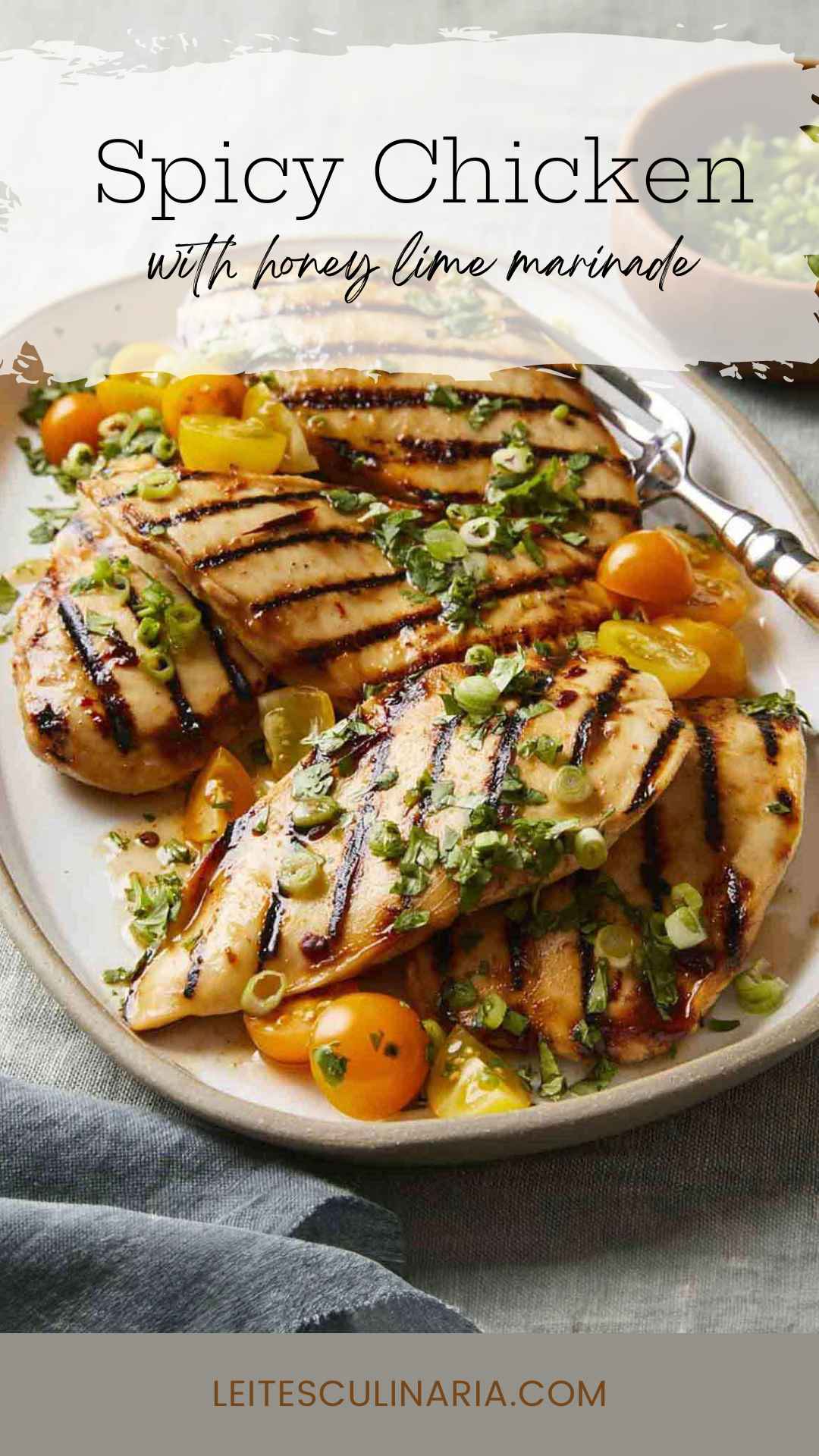 Several grilled chicken breasts on a platter with halved cherry tomatoes and scallions on top.