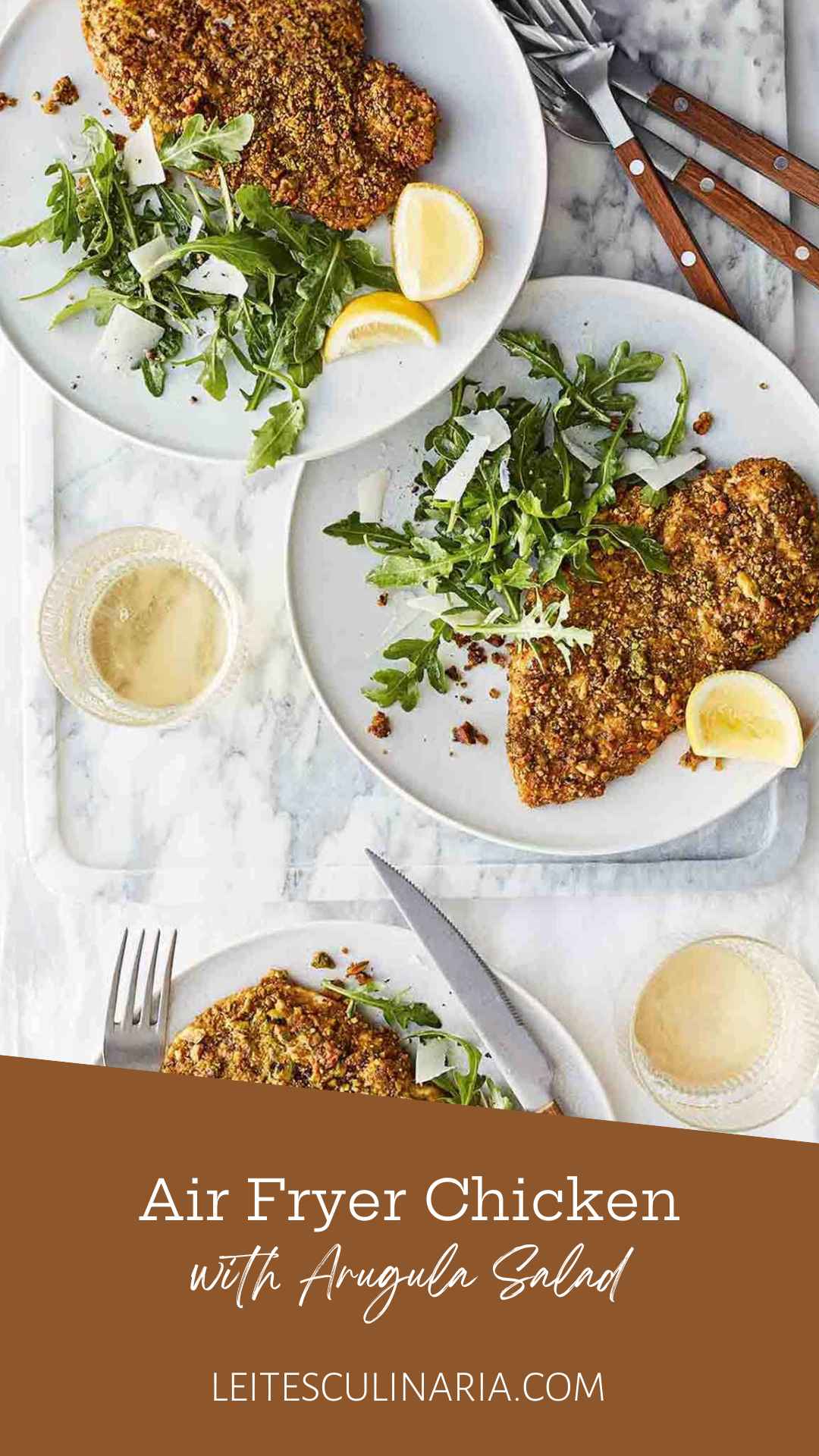 Three plates with a pistachio-crusted chicken cutlet, a lemon wedge, and an arugula and Parmesan salad on each one.