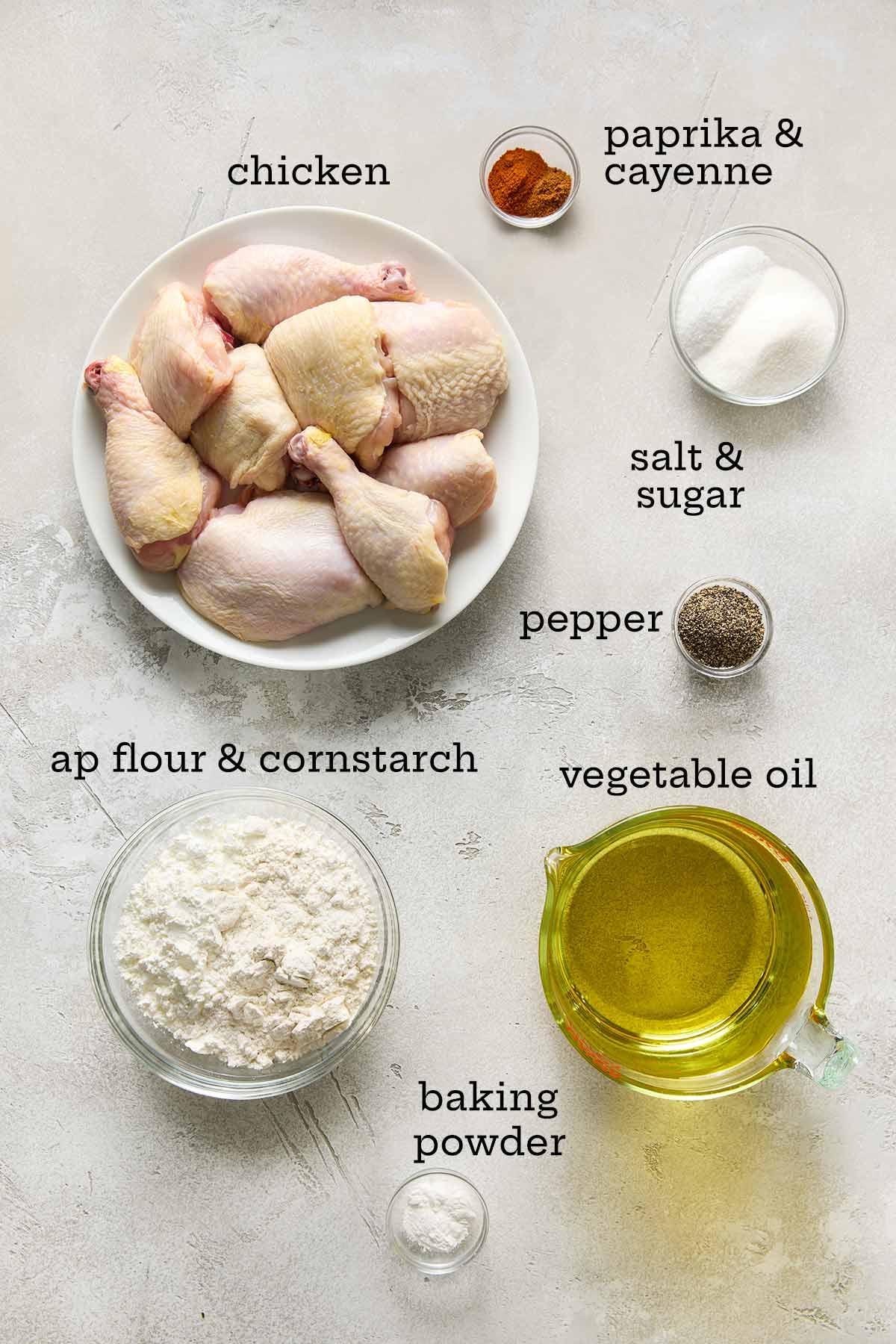 Ingredients for batter-fried chicken--chicken pieces, spices, sugar and salt, flour and cornstarch, baking powder, and oil.