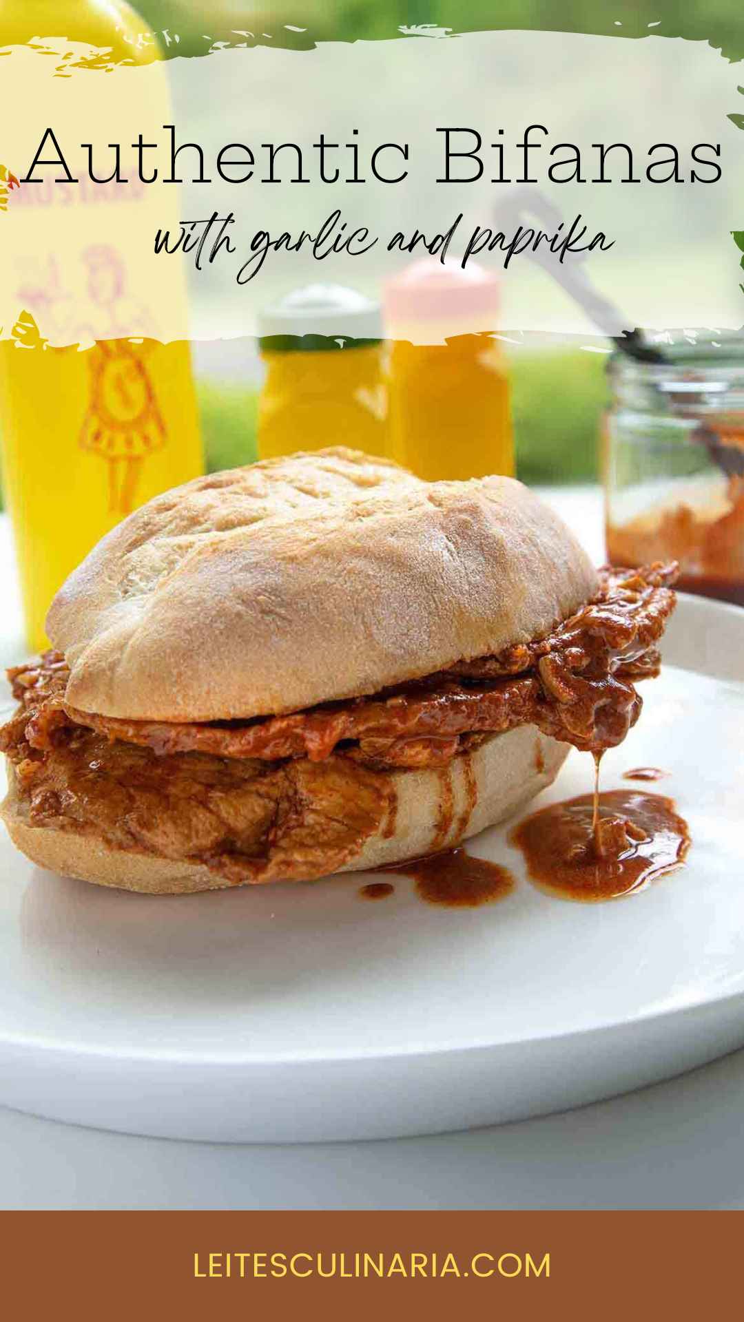 A sandwich made with a large roll, thinly sliced pork, and a paprika sauce dripping out of it on a white plate.