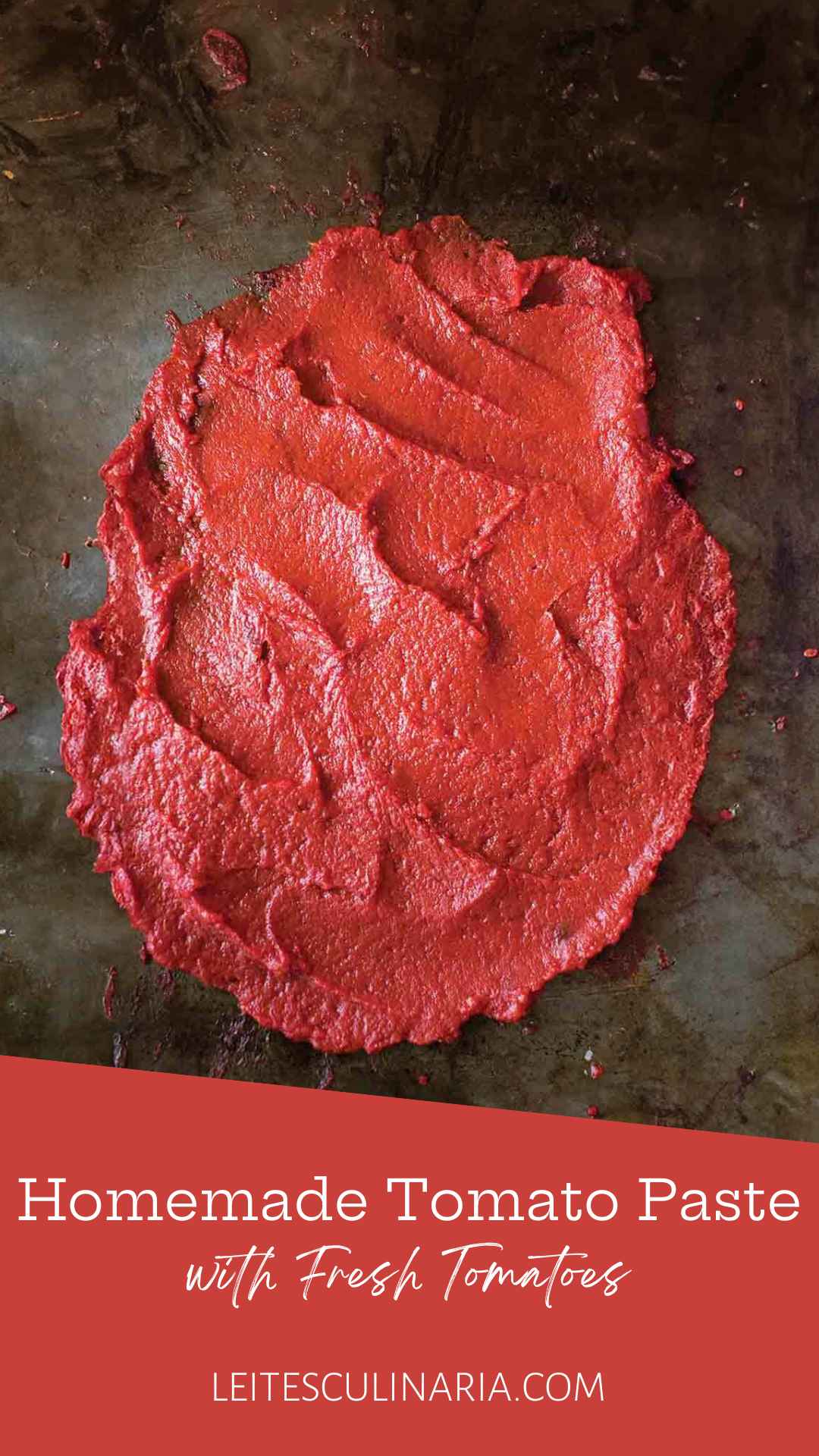 A thick layer of homemade tomato paste spread on a dark surface.