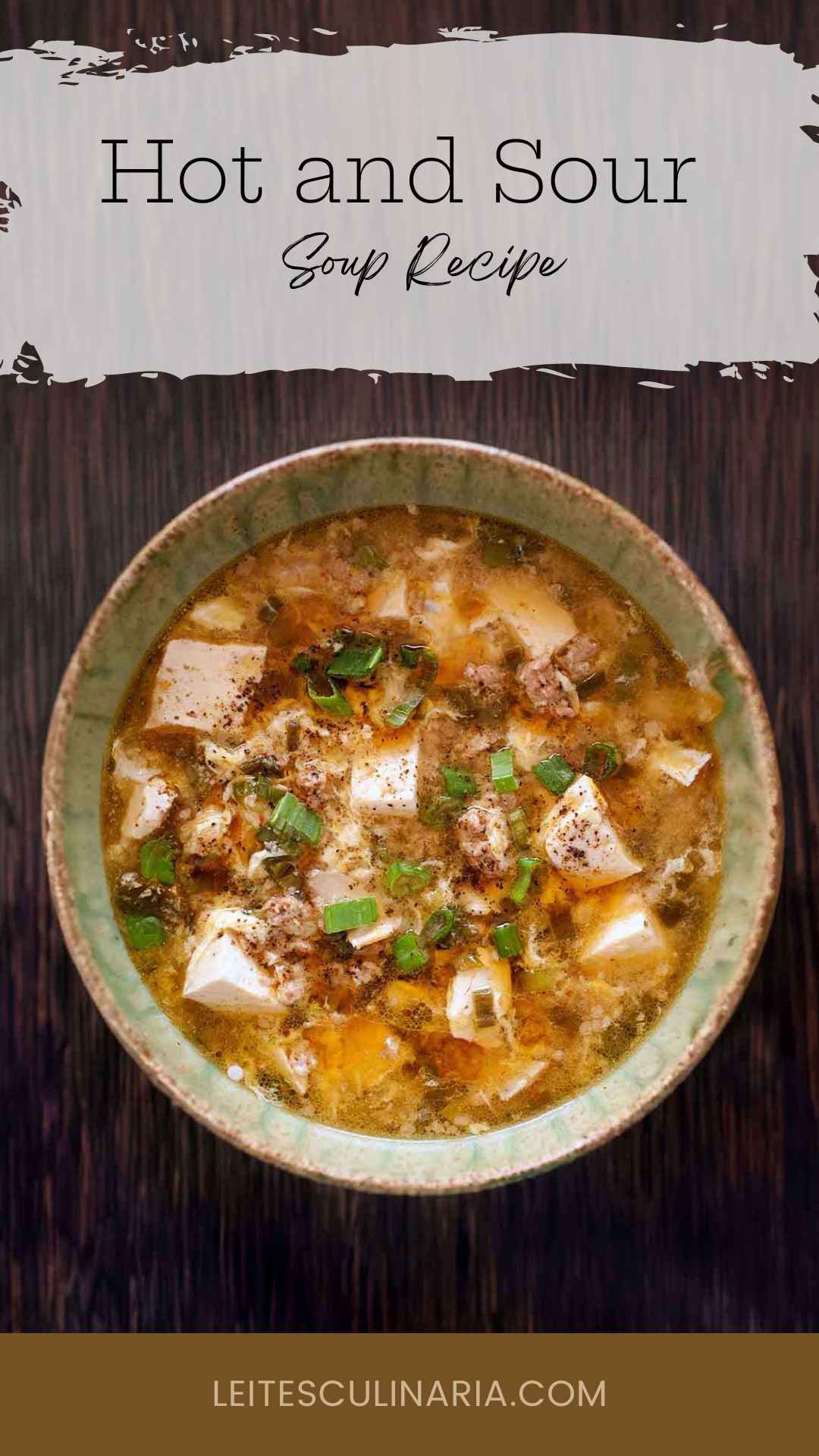 A bowl of hot and sour soup with tofu cubes and ground pork, topped with sliced scallions.