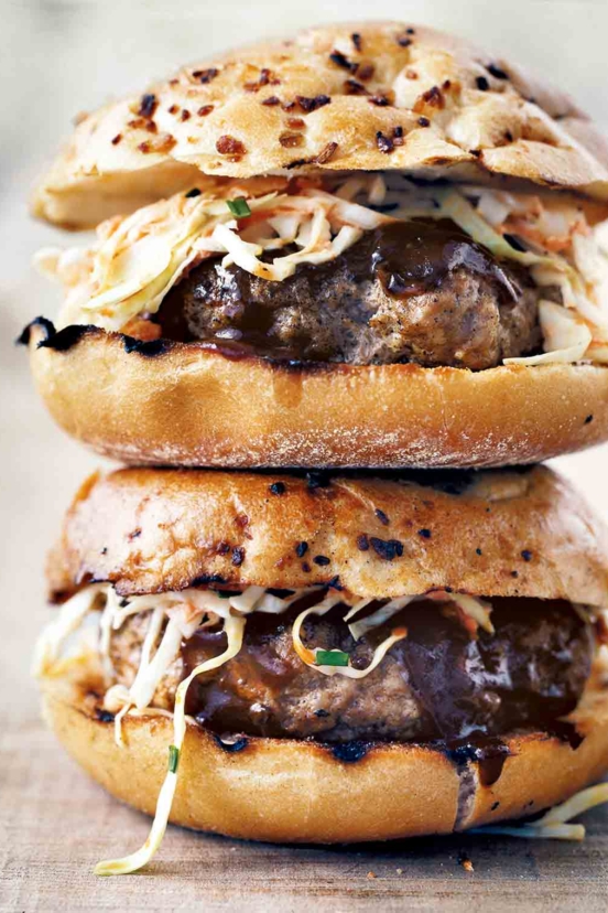 Two barbecue pork burgers with coleslaw stacked on top of each other.