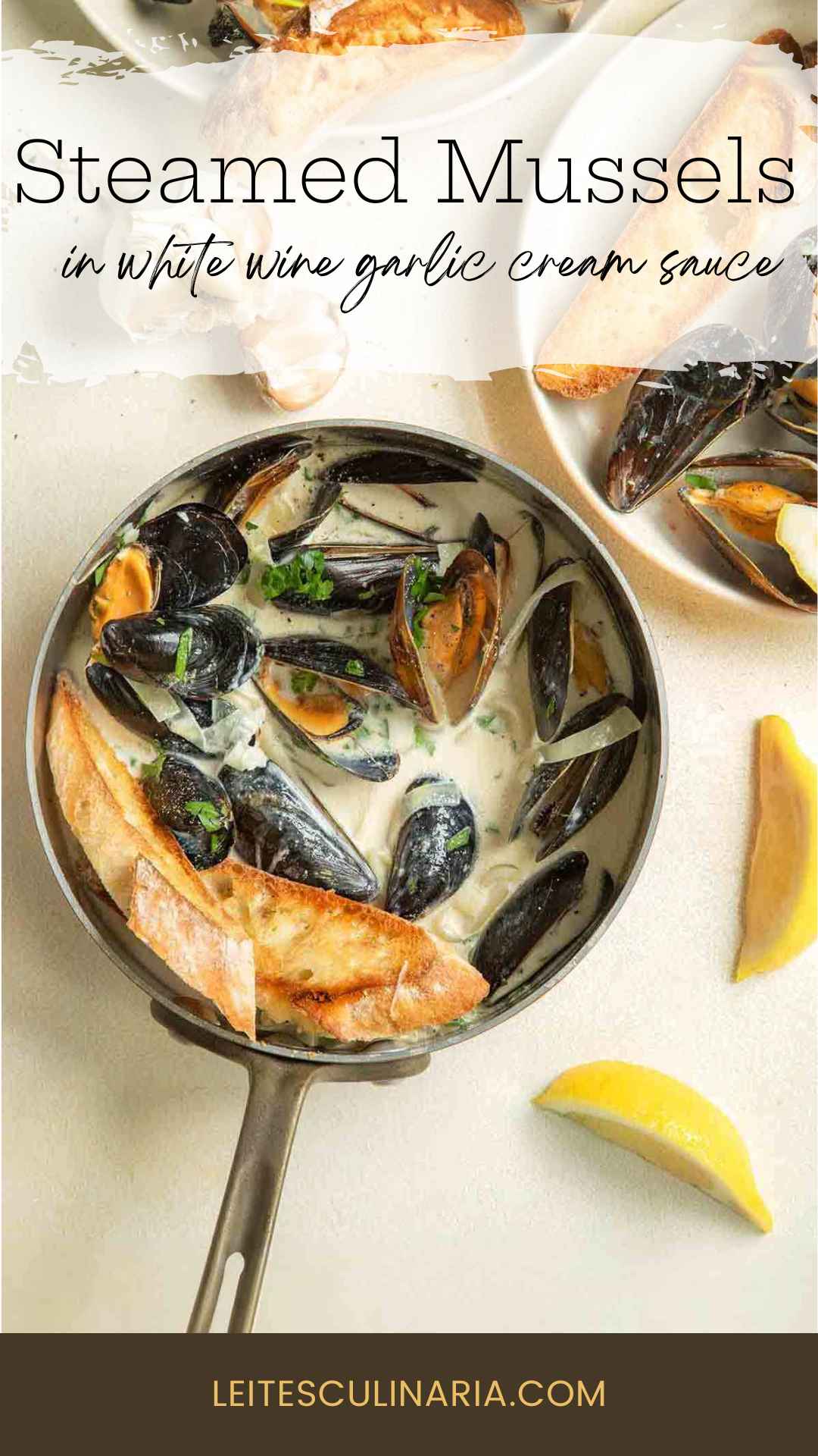 A skillet filled with steamed mussels in a creamy garlic white wine sauce with toasted bread and lemon wedges on the side.