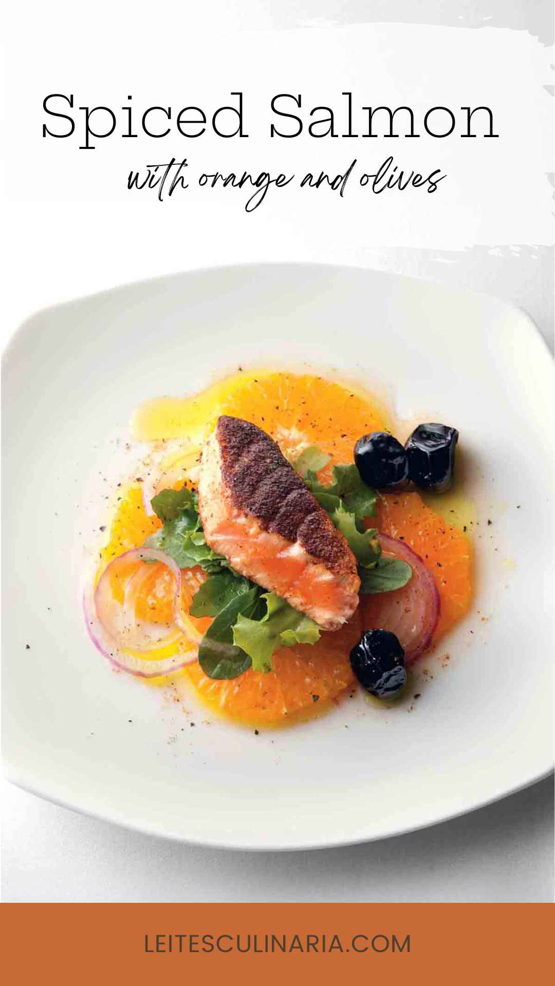 A piece of crispy salmon on top of sliced oranges, lettuce, black olives, and thinly sliced red onion on a white plate.