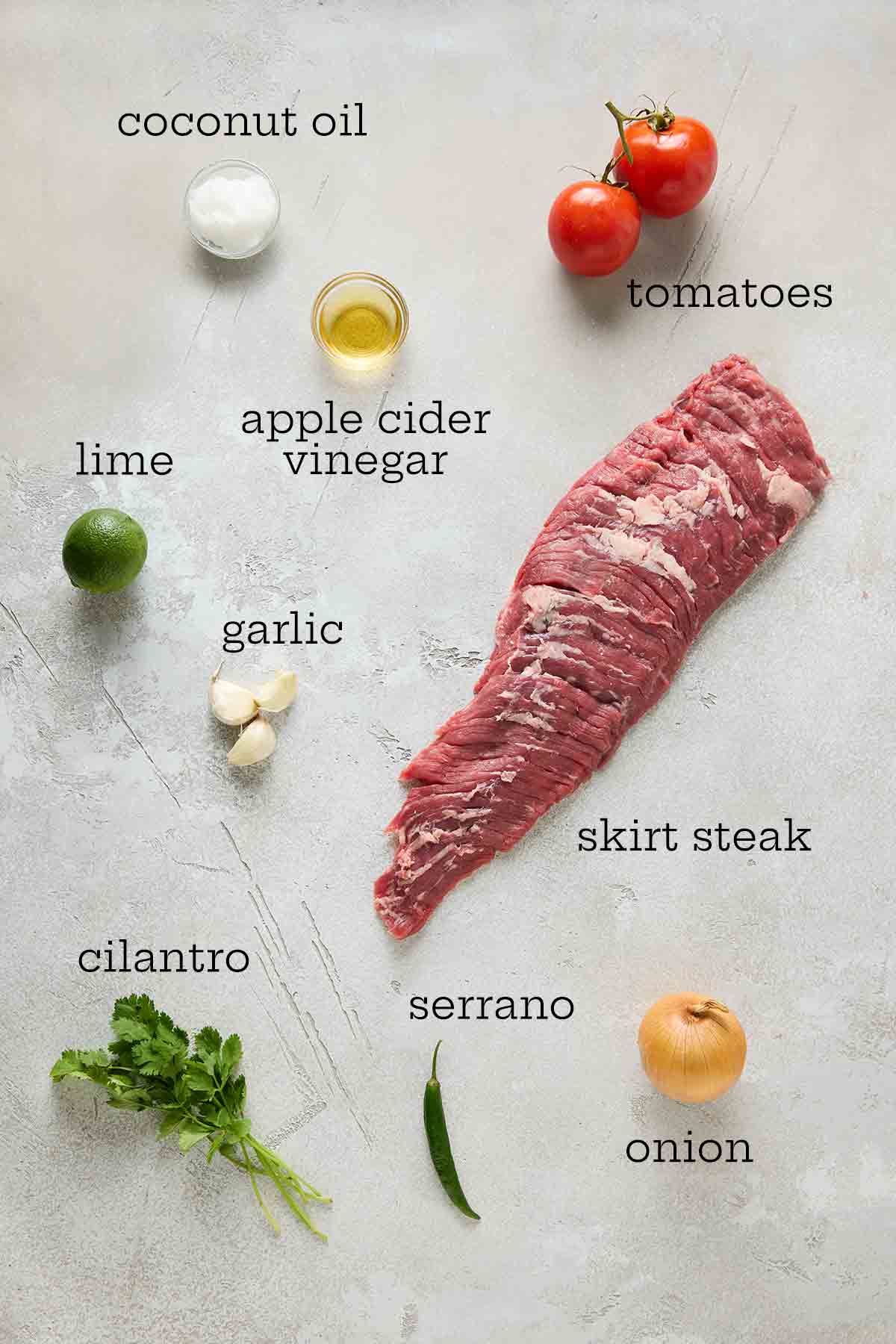 Ingredients for seared skirt steak with salsa--coconut oil, tomatoes, apple cider vinegar, lime, garlic, skirt steak, cilantro, serrano, and onion.