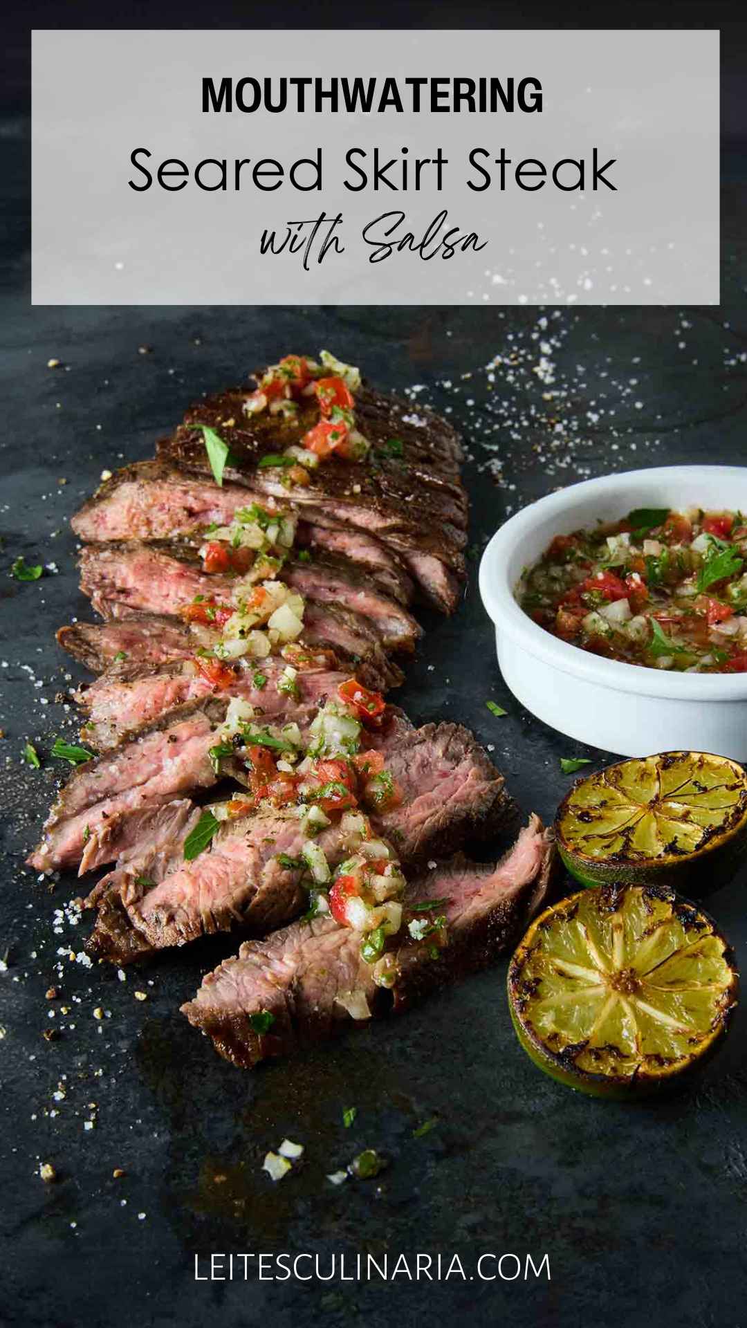 Sliced skirt steak topped with salsa with a bowl of salsa and charred lime halves on the side.