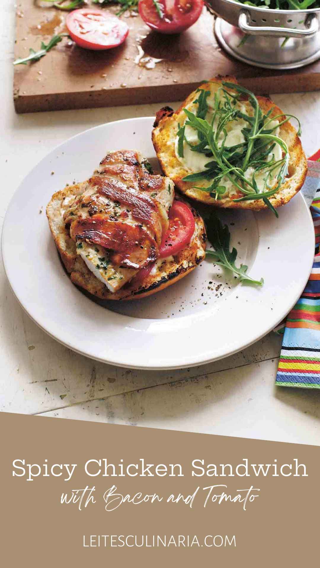 A spicy grilled chicken sandwich with bacon, tomato, and arugula on a white plate.