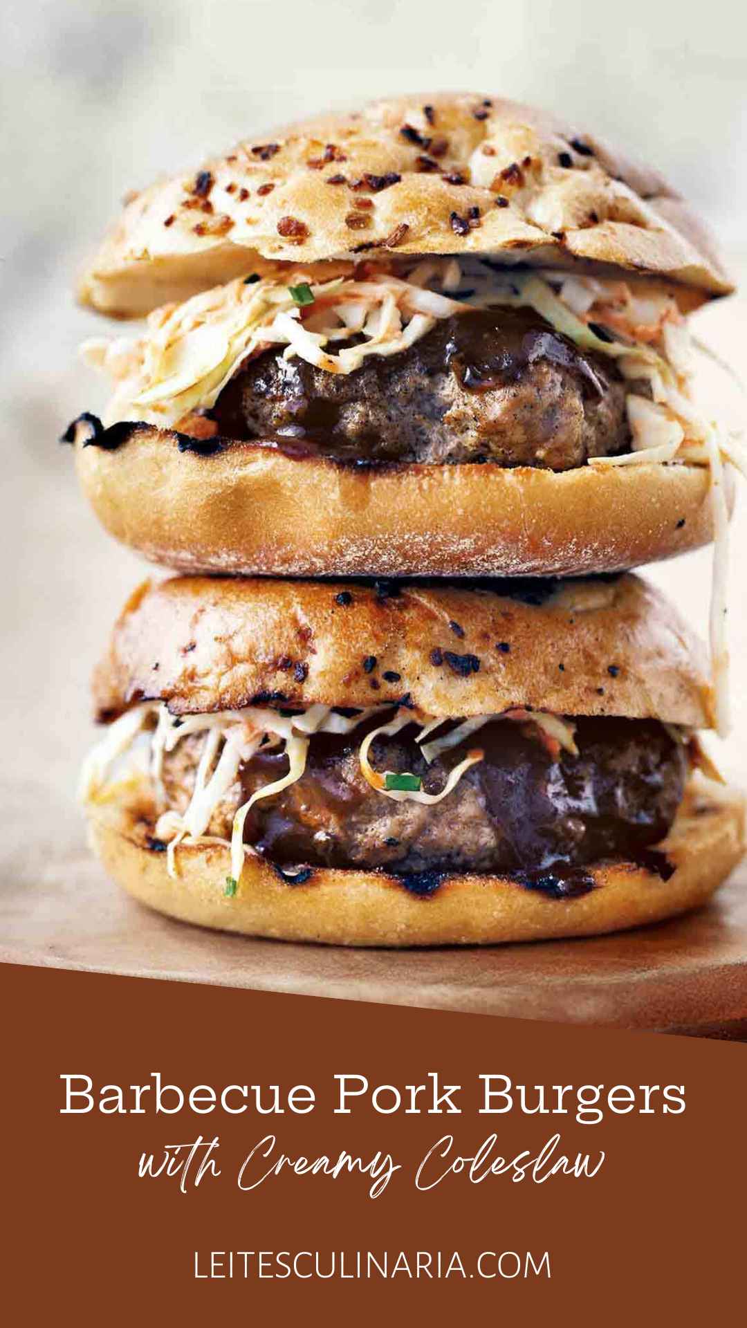Two barbecue pork burgers with coleslaw and barbecue sauce on onion buns stacked on top of each other.